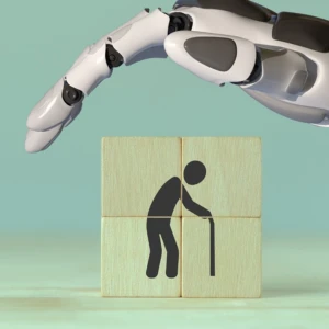 Holzwürfel mit ,,alter Mensch mit Gehstock" und Roboterhand schützend darüber